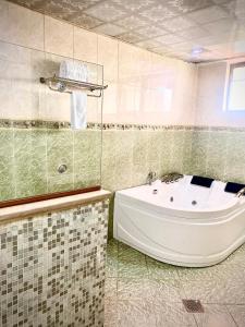 ein Badezimmer mit einer Badewanne und einem Waschbecken in der Unterkunft De Leopol Hotel in Addis Abeba