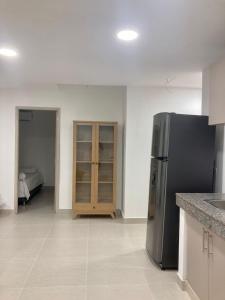 1 dormitorio y cocina con nevera de acero inoxidable. en Casa Sonia en Cartagena de Indias