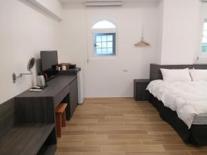 - une chambre avec un lit et un bureau dans l'établissement Diamond Avenue Homestay, à Changbin