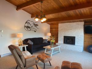 a living room with a couch and a fireplace at April Point Harbour House in Quathiaski Cove