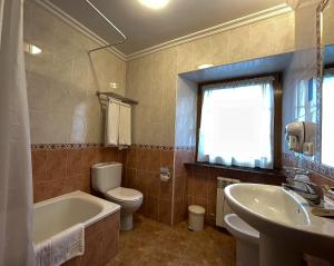 La salle de bains est pourvue d'une baignoire, de toilettes et d'un lavabo. dans l'établissement Hotel Rural "La Ruta De Cabrales", à Mestas de Con