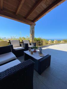 a patio with couches and a table and chairs at Casa panoramica Villasimius in Villasimius