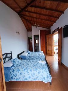 1 dormitorio con 2 camas y techo de madera en Hotel Monte verde, en Salento