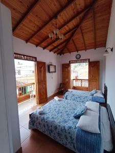 two beds in a room with wooden ceilings and windows at Hotel Monte verde in Salento