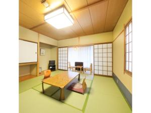 Habitación con mesa, sillas y pantalla. en Kasuga no mori - Vacation STAY 80247v, en Saku