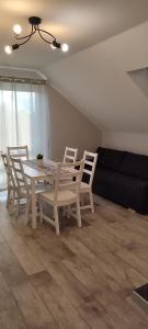 uma sala de jantar com uma mesa branca e cadeiras em Apartamenty Wilga em Wilga