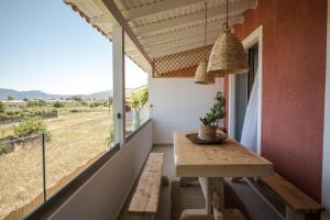 a balcony with a wooden table and a window at Nomas Living in Kalamaki