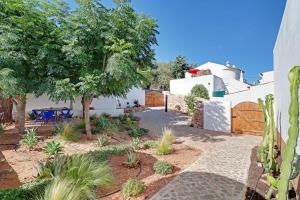 a courtyard with a garden and a house at Casa Pedra São Romão in São Brás de Alportel