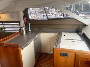 a small kitchen in a boat with a window at Tranquility Yachts -a 52ft Motor Yacht with waterfront views over Plymouth. in Plymouth