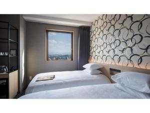 two beds in a hotel room with a window at Tmark City Hotel Kanazawa - Vacation STAY 90395v in Kanazawa