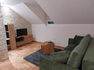 a living room with a couch and a tv at Apartmani Eho Zlatibor in Zlatibor