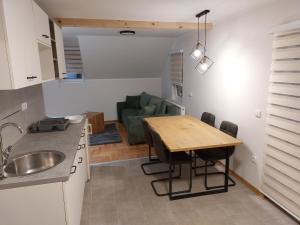 a kitchen and dining room with a table and a couch at Apartmani Eho Zlatibor in Zlatibor
