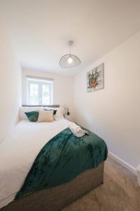 Un dormitorio con una cama con una manta verde. en Stylish 2-bed home - For Company contractor and Leisure stays - NEC, Airport, HS2, Contractors, Resort World, en Birmingham