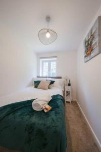 um quarto com uma cama grande e um cobertor verde em Stylish 2-bed home - For Company contractor and Leisure stays - NEC, Airport, HS2, Contractors, Resort World em Birmingham