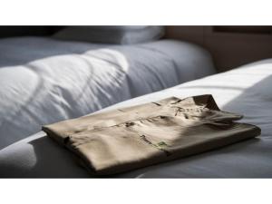a brown shirt sitting on top of a bed at Tmark City Hotel Kanazawa - Vacation STAY 90378v in Kanazawa