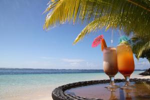 two cocktails sitting on a table on the beach at Stevensons at Manase in Manase