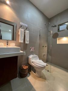 uma casa de banho com um WC, um lavatório e um chuveiro em Hotel Ko'ox Wenne em Tulum