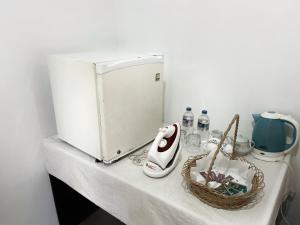 a white counter with a microwave and a basket of items at Crystal Lake Resort in Kandy