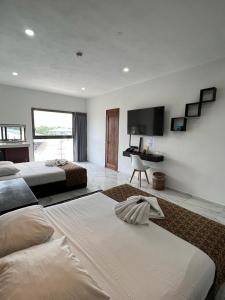 duża sypialnia z 2 łóżkami i biurkiem w obiekcie Hotel Ko'ox Wenne w mieście Tulum
