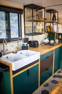 uma cozinha com um lavatório branco e armários azuis em Inspire Tiny em Saint-Laurent