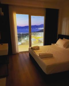 a bedroom with a bed and a large window at SEA & LAKE VIEW VILLA in (( Kalive Gjoka ))