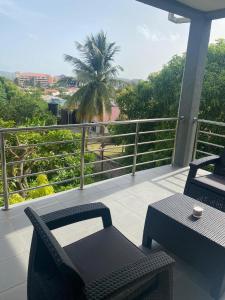 balkon ze stołem, krzesłami i palmą w obiekcie Belle Luxury Apartments w mieście Gros Islet