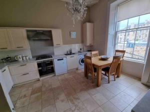 a kitchen with a table and chairs and a dining room at Beautiful Georgian New Town Flat in Edinburgh