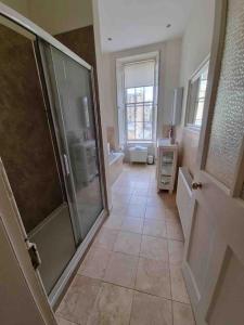 a large bathroom with a walk in shower and a glass door at Beautiful Georgian New Town Flat in Edinburgh