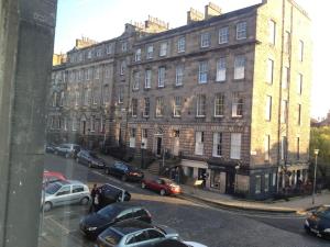 a city street with cars parked in front of a building at Beautiful Georgian New Town Flat in Edinburgh