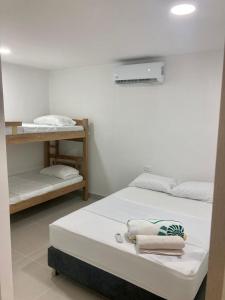 um quarto com duas camas e uma prateleira em Casa Sonia em Cartagena de Indias