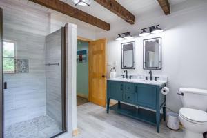 uma casa de banho com um lavatório azul e um chuveiro em Enchanted Forest Retreat em Dandridge