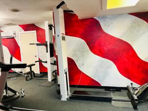 a gym with a red painting on the wall at The Classic Desert Aire Hotel in Alamogordo