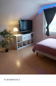 1 dormitorio con 1 cama y TV de pantalla plana en Cozy 4-bedroom villa free parking big garden ++, 