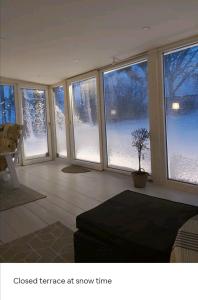 a living room with snow outside the windows at Cozy 4-bedroom villa free parking big garden ++ 