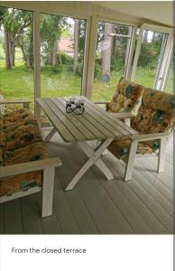 una mesa de picnic de madera y 2 sillas en el porche en Cozy 4-bedroom villa free parking big garden ++, 