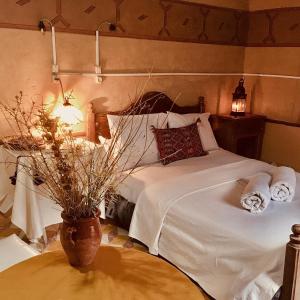una camera con un letto e un vaso su un tavolo di Hôtel panoramique de la vallée ad Aït Idaïr
