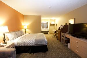 a hotel room with two beds and a television at Bow River Inn in Cochrane