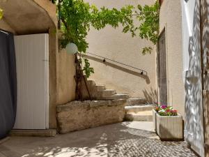 un escalier avec une porte blanche et quelques fleurs dans l'établissement Maison de village avec cour intérieure et terrasse, à Septfonds