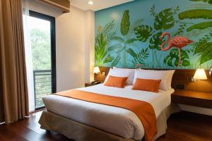 um quarto com uma cama grande e uma pintura na parede em Giraffe Boutique Hotel em Baguio