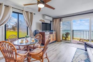 uma sala de estar com uma mesa e cadeiras e uma televisão em Pono Kai Resort em Kapaa