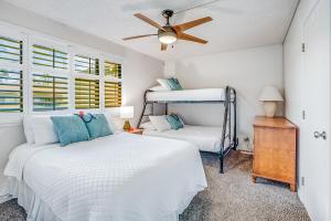 a bedroom with two beds and a ceiling fan at Pono Kai Resort in Kapaa