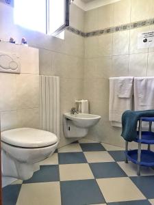 een witte badkamer met een toilet en een wastafel bij La Stazione in Premeno