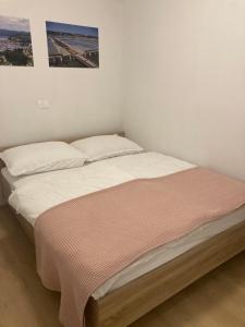 - un lit avec des draps blancs et une photo sur le mur dans l'établissement Bellevue 1, à Izola