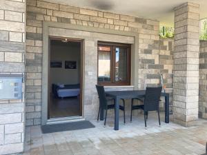 a patio with a table and chairs on a brick wall at Bellevue 1 Apartments in Izola