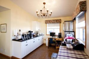 a kitchen with white cabinets and a chandelier at Bow River Inn in Cochrane