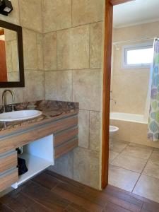 ein Badezimmer mit einem Waschbecken, einem WC und einer Badewanne in der Unterkunft Lo de Gustavo in Esquel
