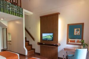 a room with a staircase and a tv in a house at Giraffe Boutique Hotel in Baguio
