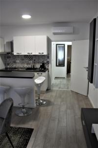 een keuken met witte kasten en een zwart aanrechtblad bij Tiziano T1 in Zagreb