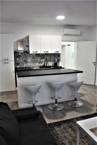 een keuken met witte kasten en een zwart aanrechtblad bij Tiziano T1 in Zagreb +5 foto's