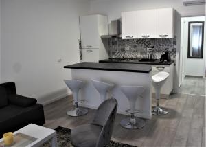 a kitchen with a counter and chairs in a living room at Tiziano T1 in Zagreb